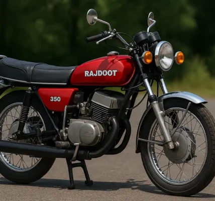 Rajdoot 350 vintage motorcycle in red color with chrome exhaust and twin-cylinder engine parked on a road in India